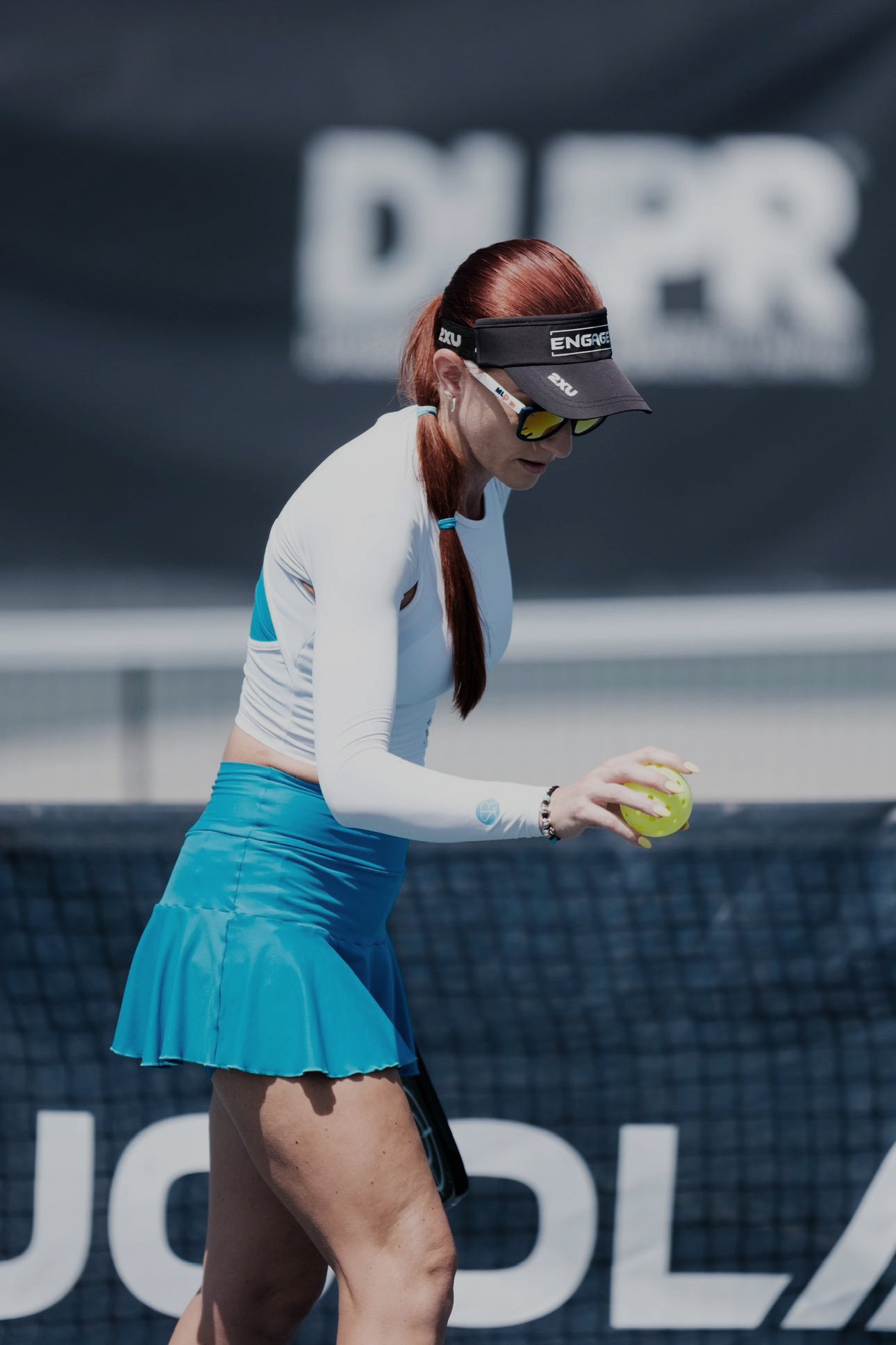 Pickleball player holding a ball wearing SParms Shoulder Wrap